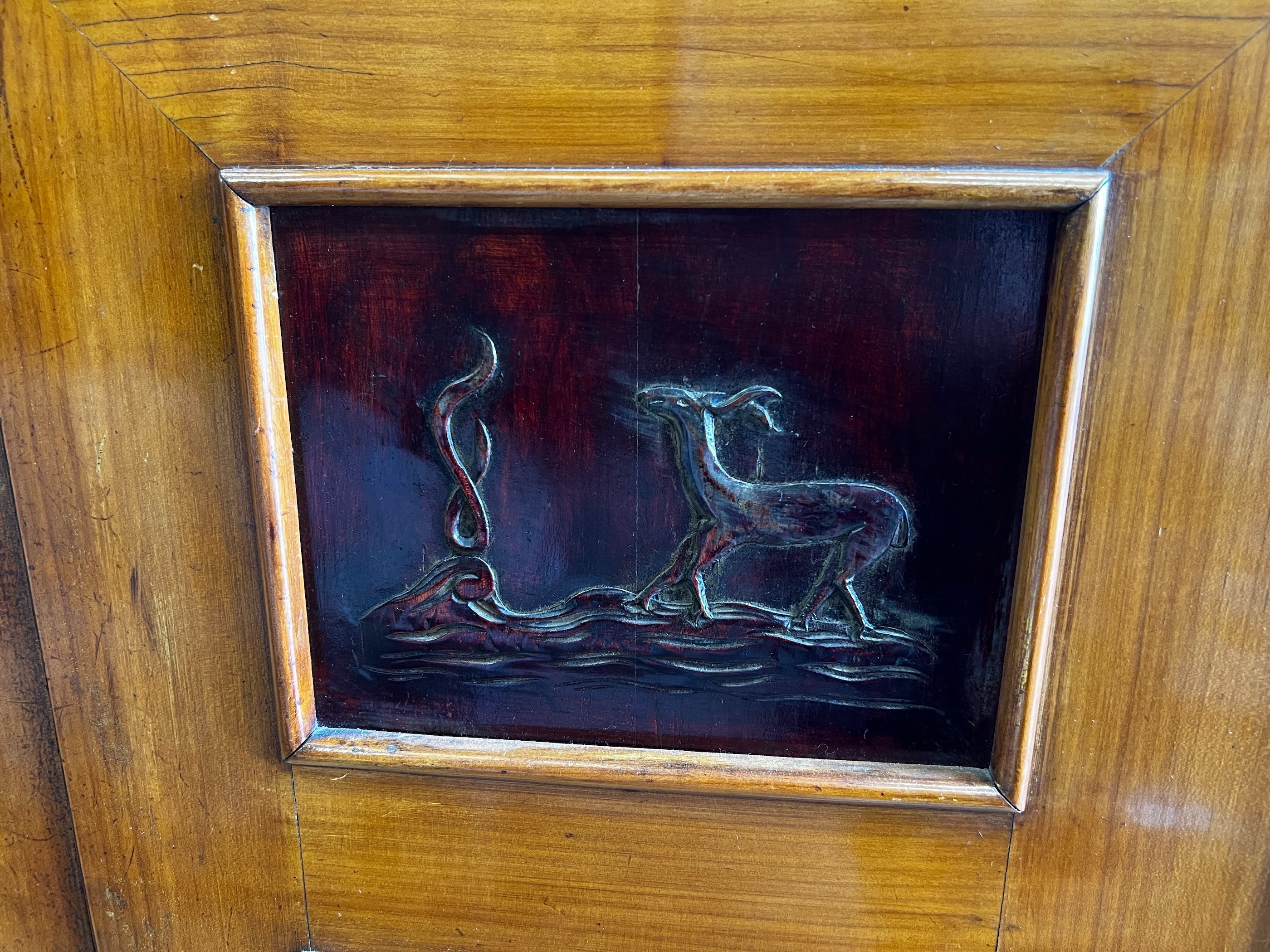 A mid century continental side cabinet, the panelled doors carved with antelope and exotic birds, width 212cm, depth 50cm, height 146cm